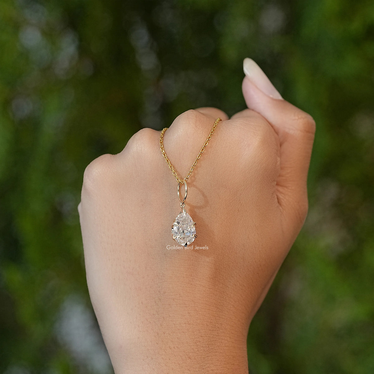 Pear-cut moissanite solitaire pendant on gold-tone chain, teardrop stone