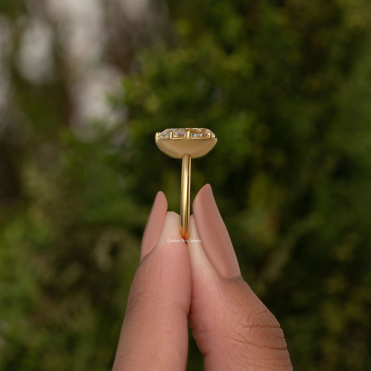 Gold-tone pear moissanite solitaire ring viewed from the side, slender band