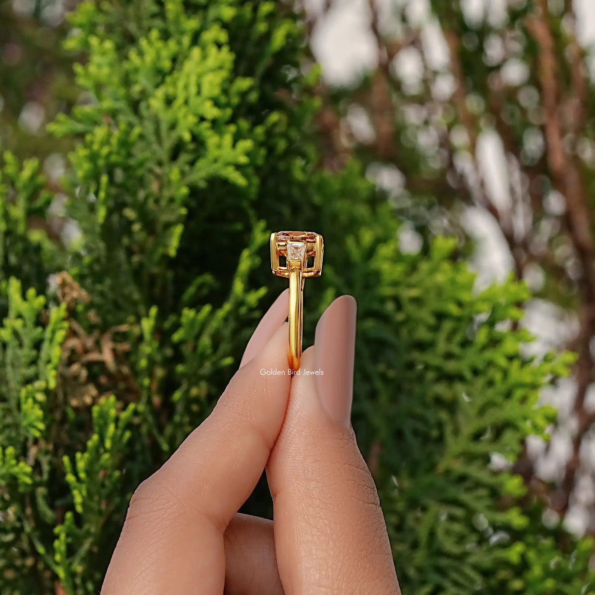 Gold three-stone engagement ring, side view: cushion center with baguette accents