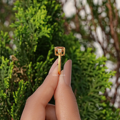 Gold three-stone engagement ring, side view: cushion center with baguette accents