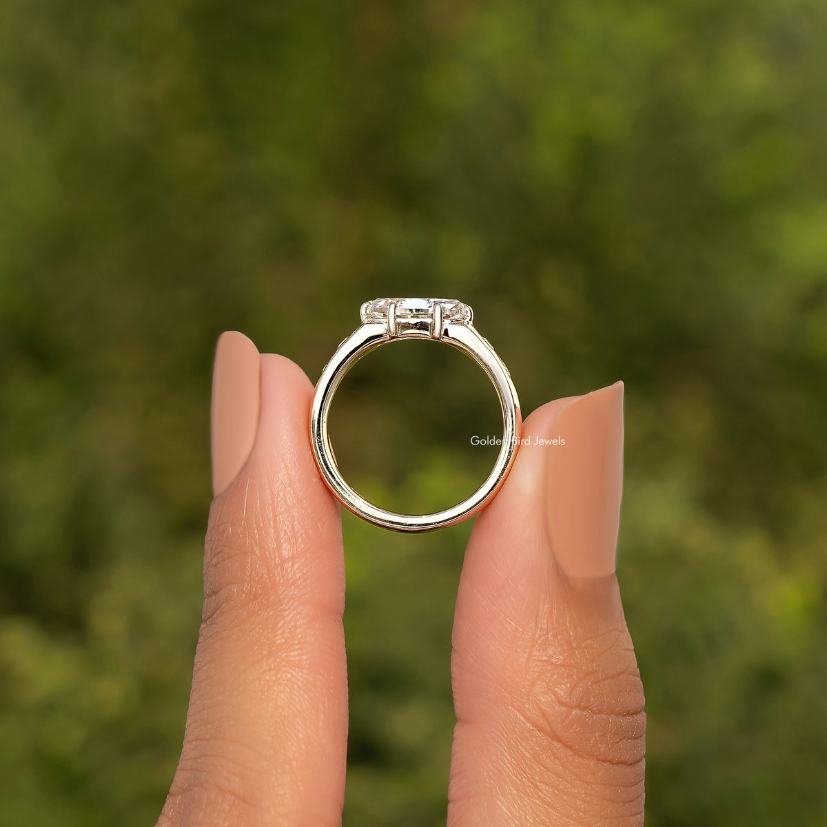 Gold moissanite ring with prongs and clear center stone, top view