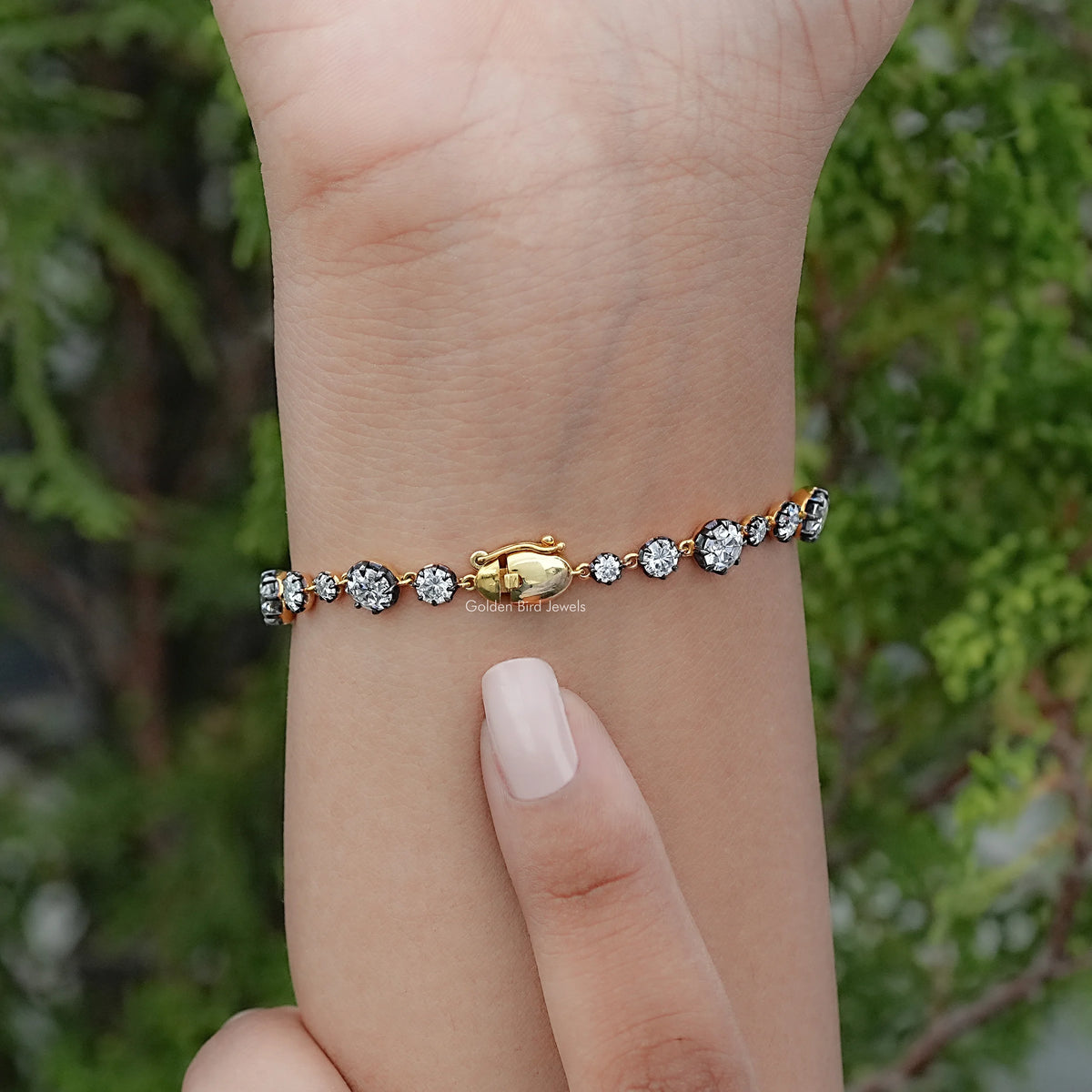 Round-stone tennis bracelet with silver prong setting, worn on wrist