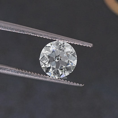 Round old European cut lab grown diamond between two silver-toned prongs