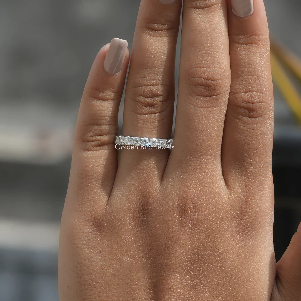 3/4 eternity band ring with round-cut moissanite stones on a slim metal band