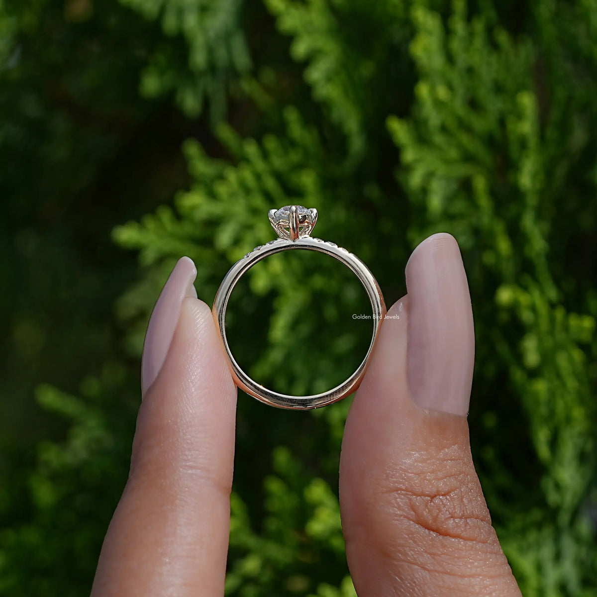 Back View A Round Cut Lab Diamond Accent Ring In two fingers