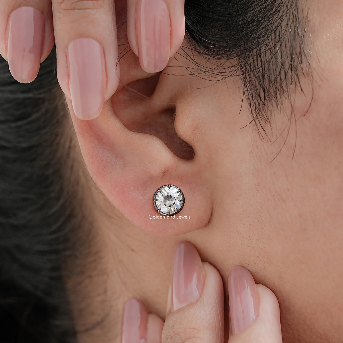 Round moissanite stud earrings on ear, single earring visible