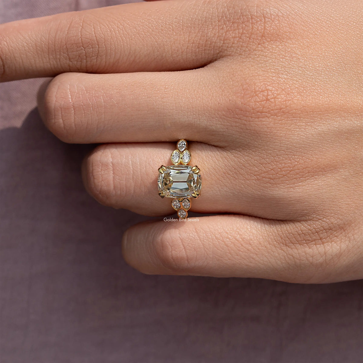 Cushion-cut moissanite ring on finger with round side accents
