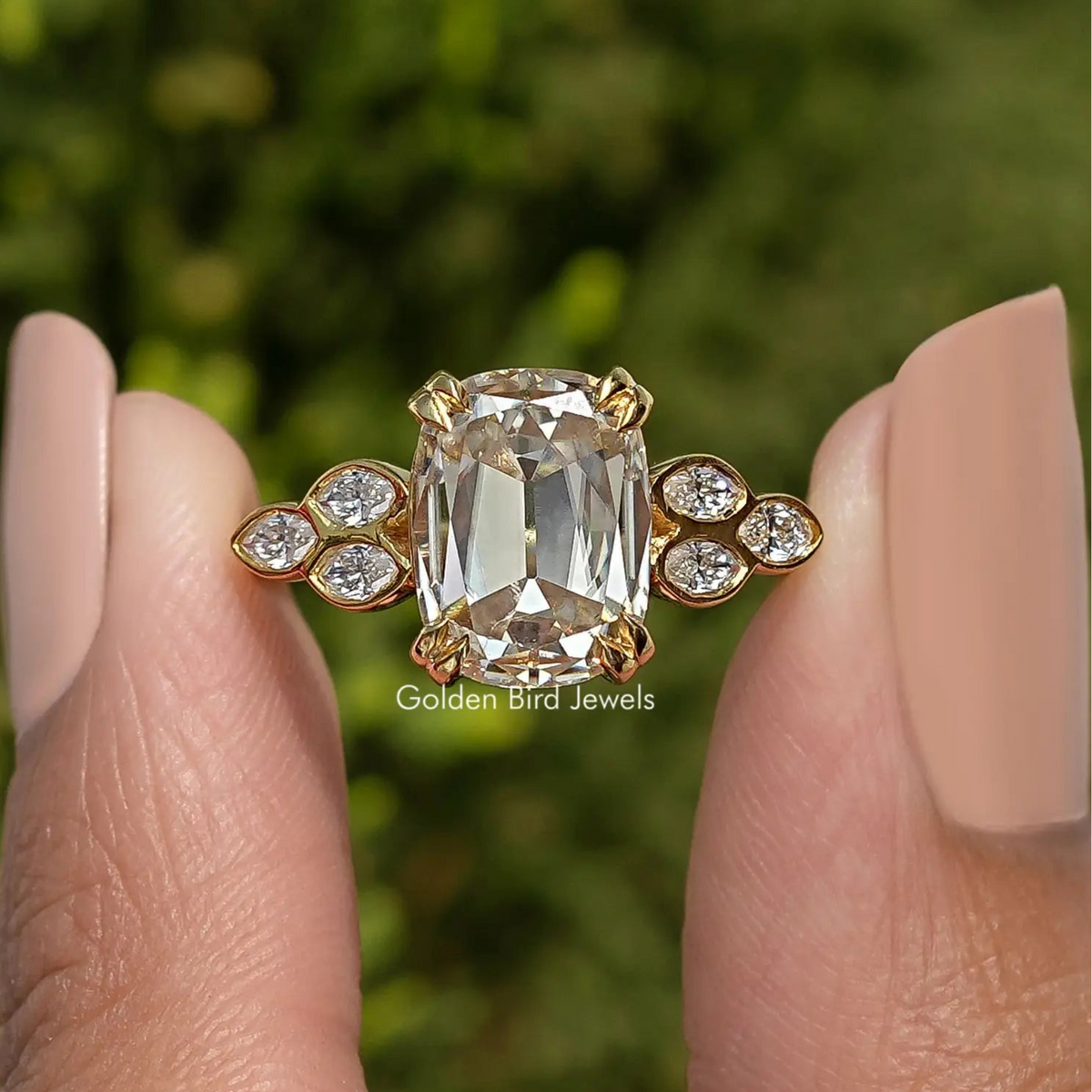 Cushion-cut moissanite center with four round side accents on gold-tone band