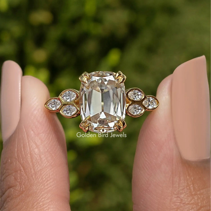 Cushion-cut moissanite center with four round side accents on gold-tone band