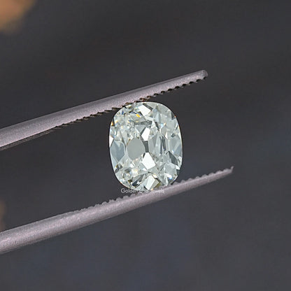 Old Mine cut lab-grown diamond close-up between tweezers, rounded cushion face.