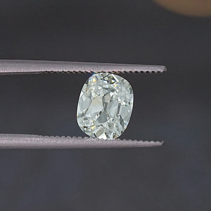 Old Mine cut lab-grown diamond view between tweezers, oval cushion facets.