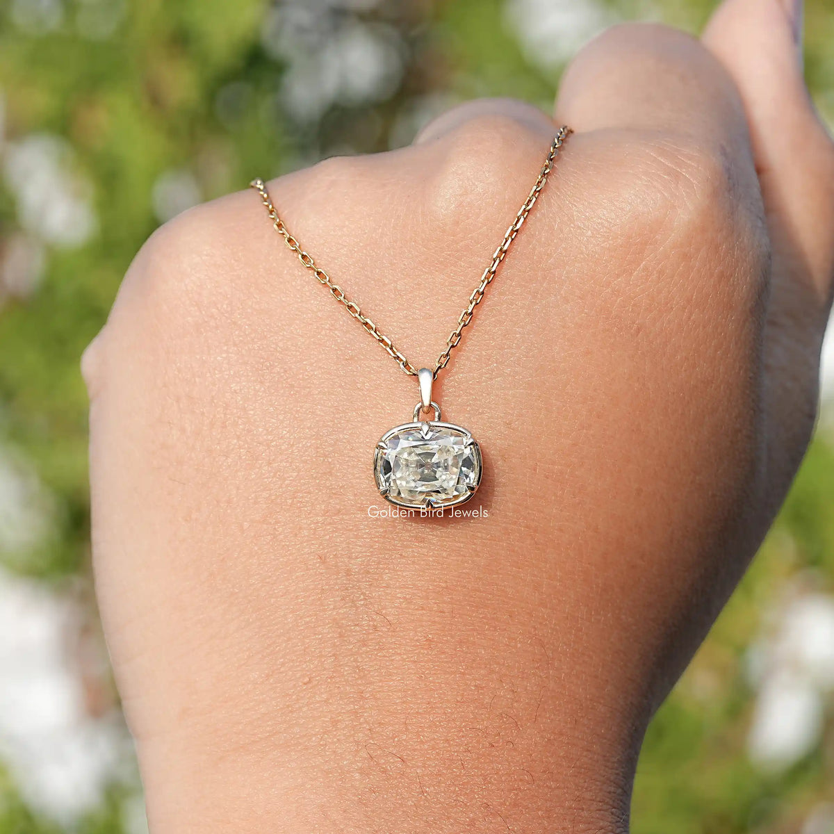 Cushion-cut moissanite pendant necklace with gold chain and round bezel on neck