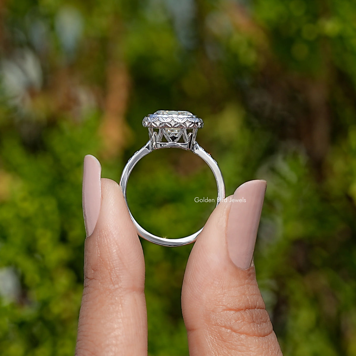 Silver cushion-cut moissanite ring on finger, halo top detail visible
