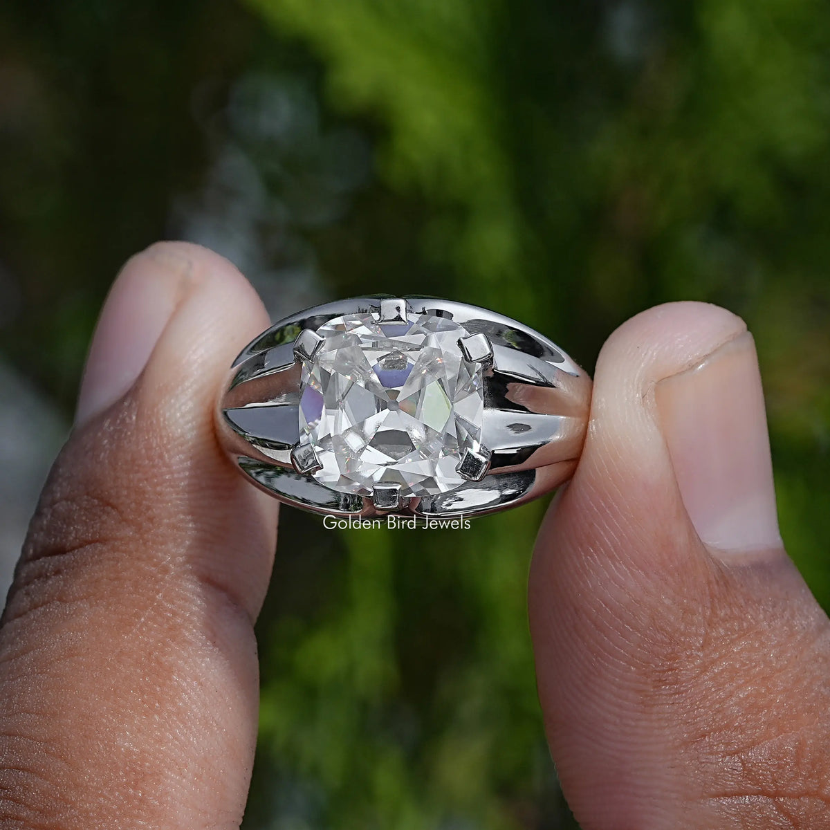 Cushion-cut solitaire moissanite ring with faceted halo-style prongs, close-up