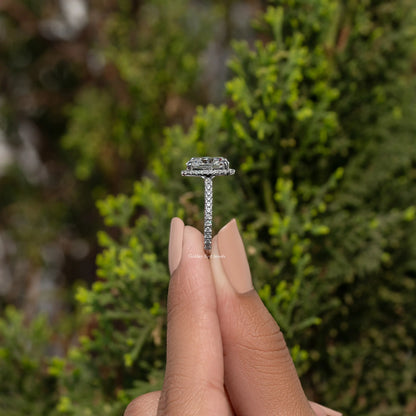 Top view of halo cushion-cut moissanite engagement ring, prong setting on finger