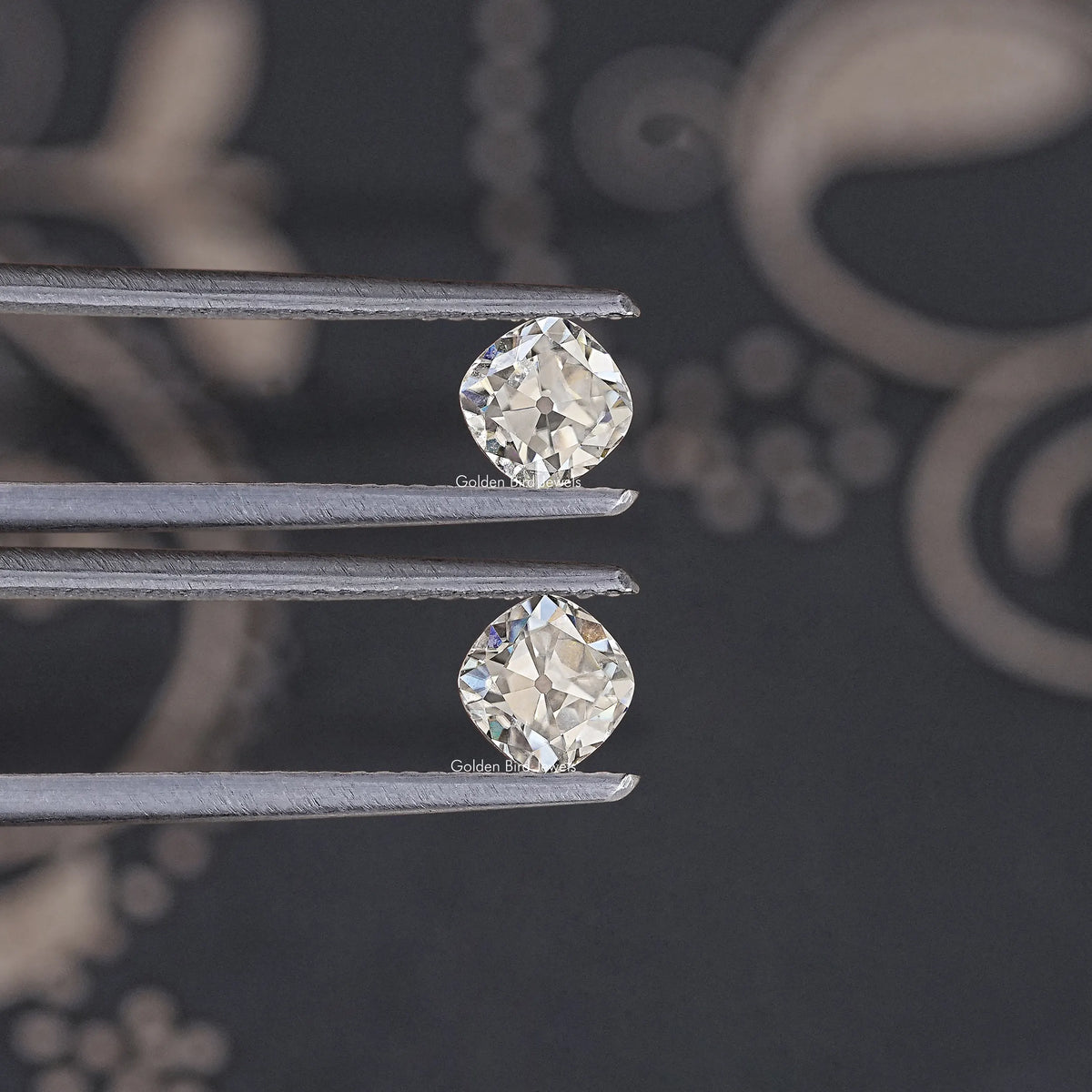 Loose cushion-cut moissanite stones, clear, close-up of two stones on prongs