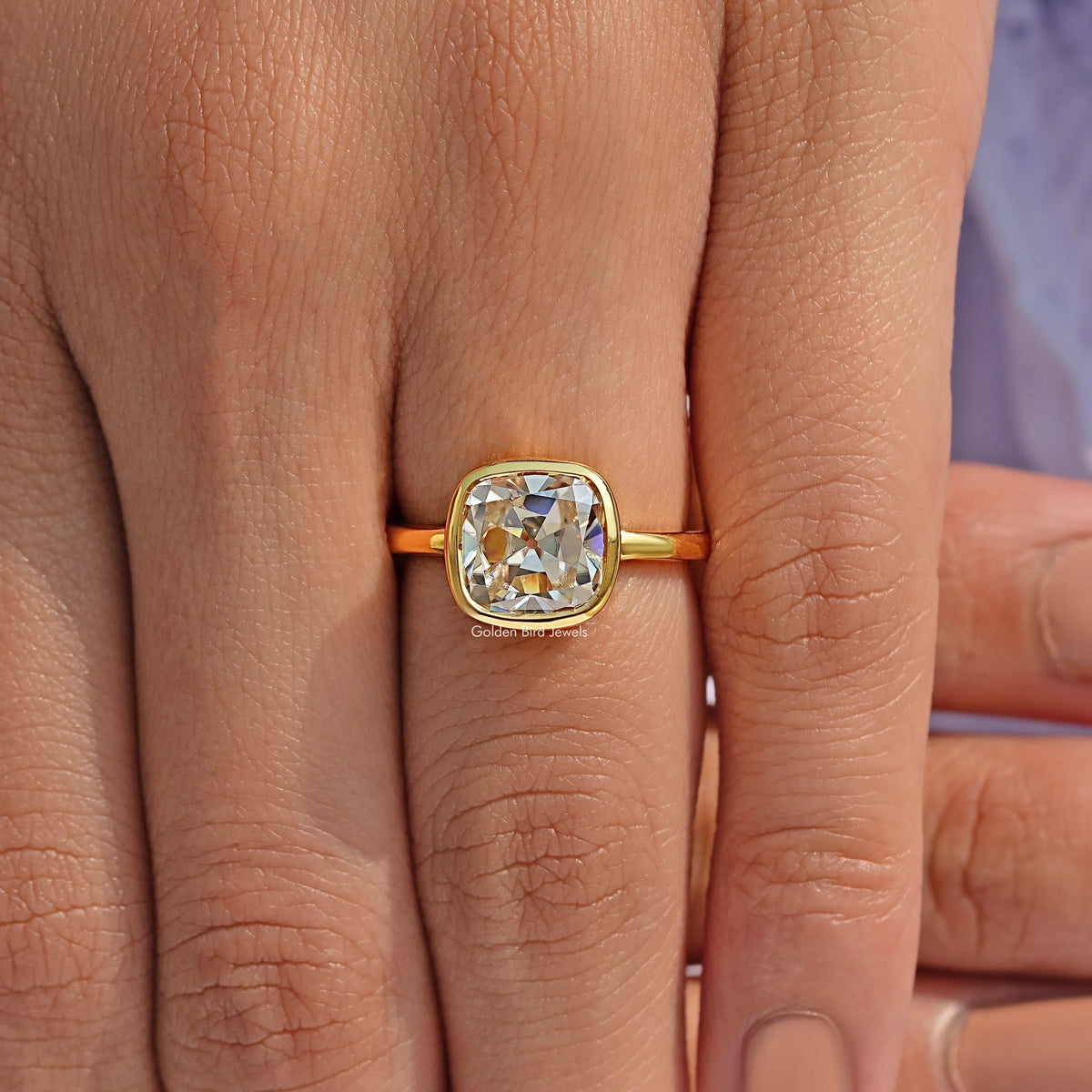 Gold solitaire ring with square cushion moissanite stone and bezel setting