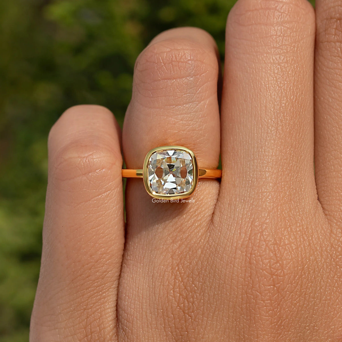 Gold-toned solitaire ring with round-edge bezel and square cushion moissanite