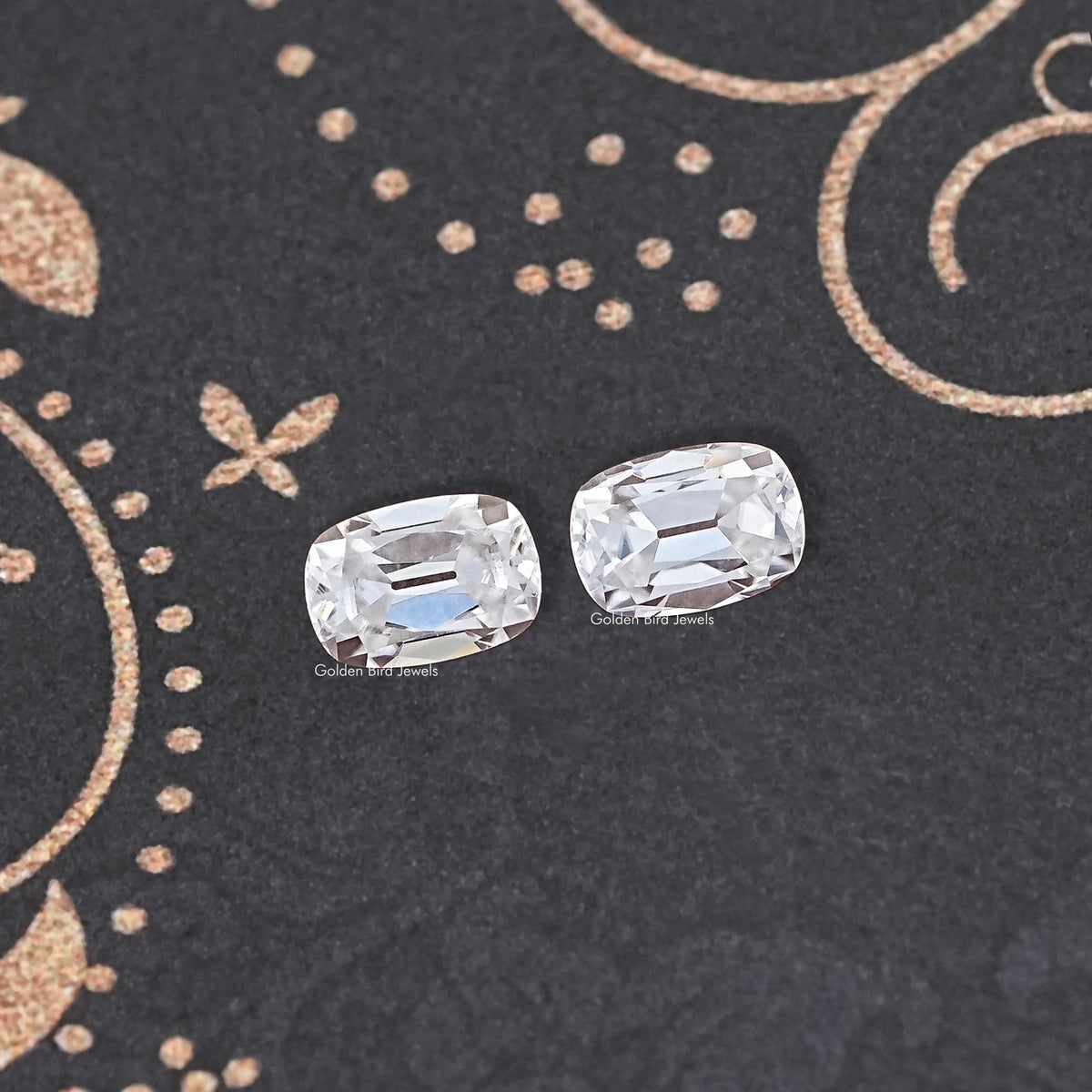Two cushion-cut colorless moissanite stones with crisp facets, loose pair