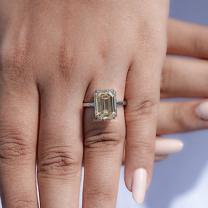 Emerald-cut moissanite solitaire ring close-up on hand, silver band and stone