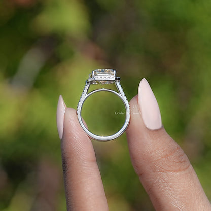 Top-down view of emerald-cut halo ring, prong set center and silver-tone band
