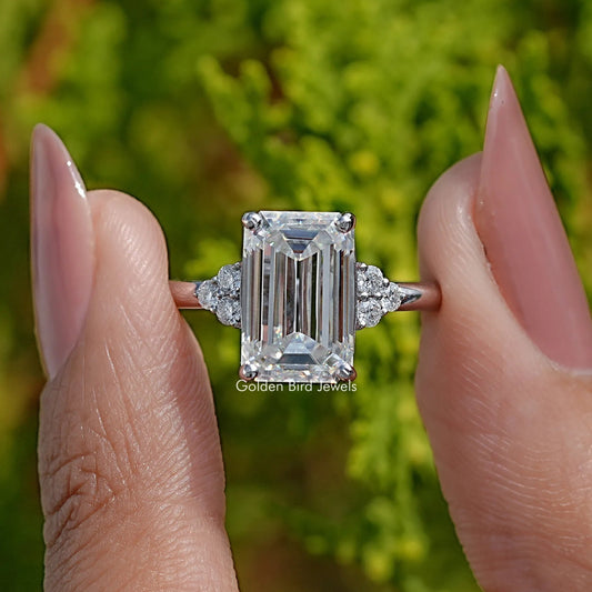 Square emerald-cut moissanite center with tapered side stones, ring close-up