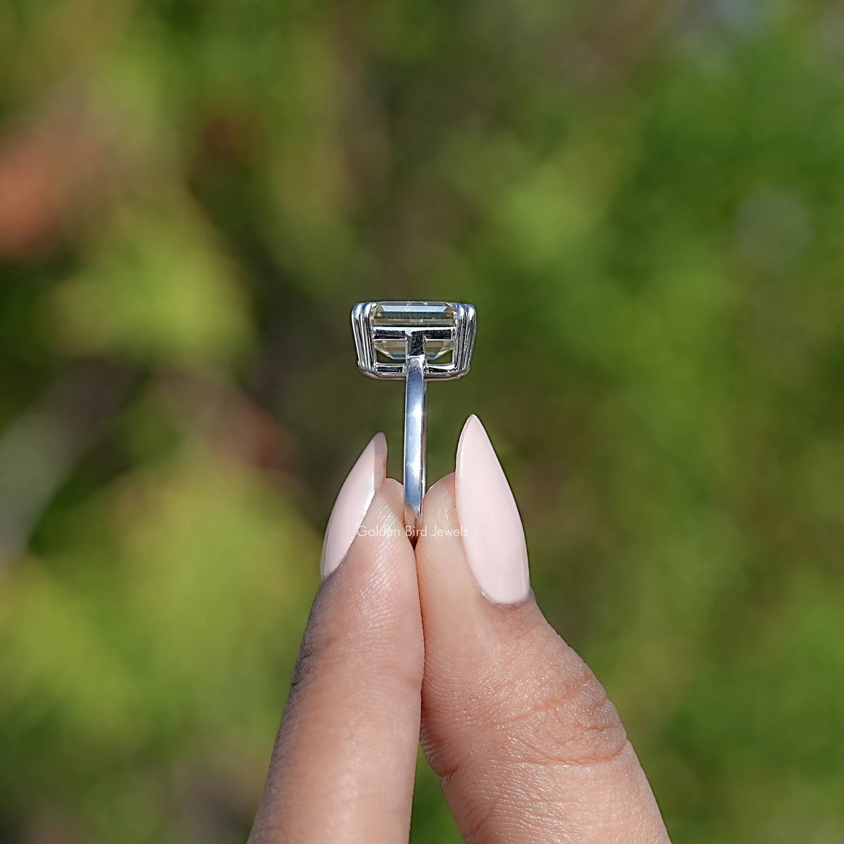 Emerald-cut moissanite solitaire ring with square prong head on silver band