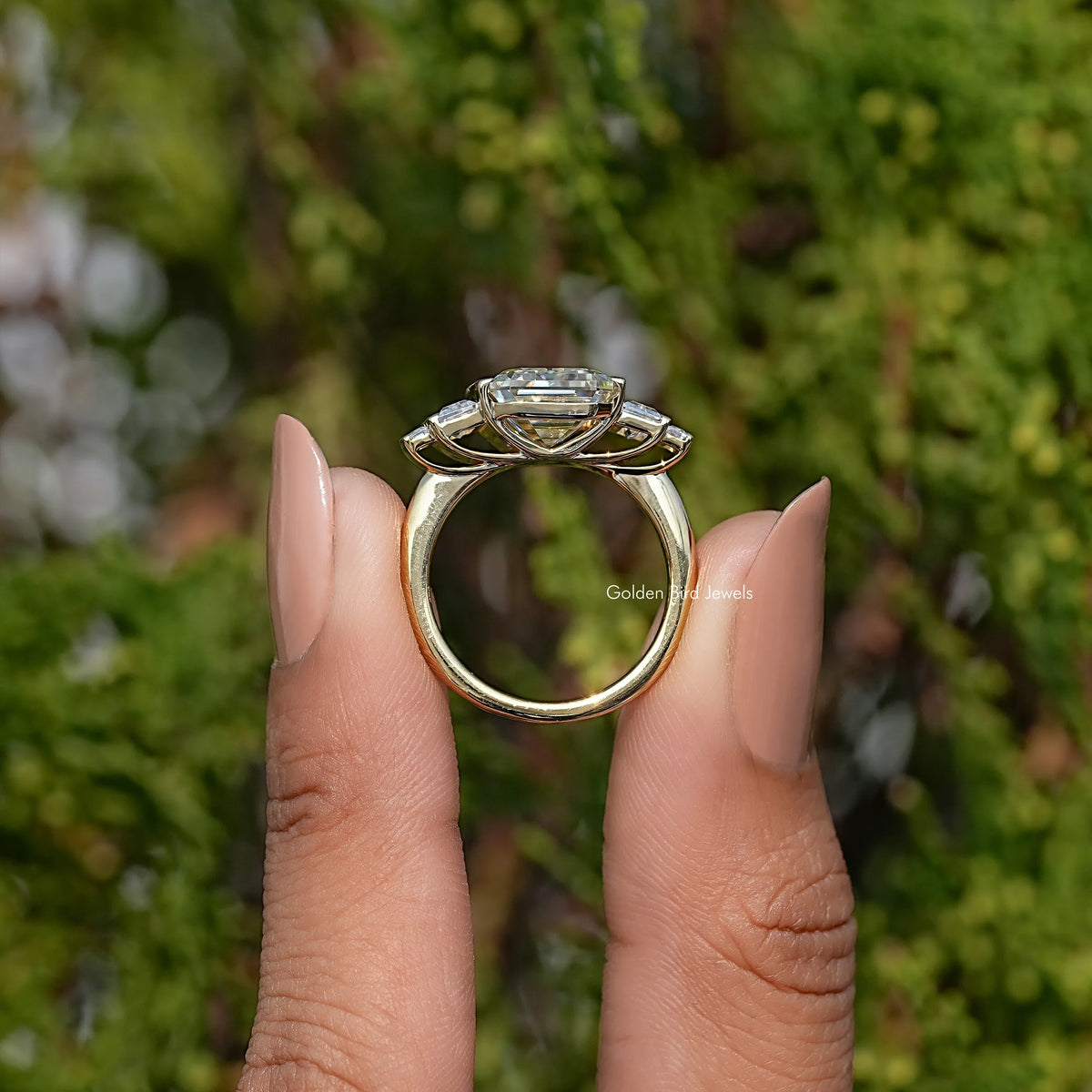 Five-stone emerald-cut ring side view, band and prongs visible