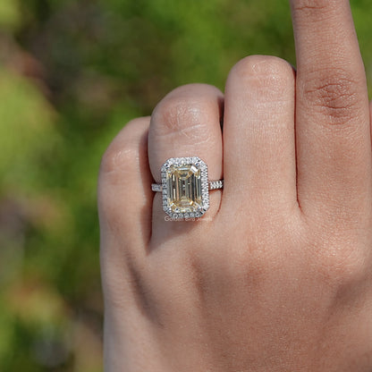 Emerald-cut moissanite halo accent ring on a finger