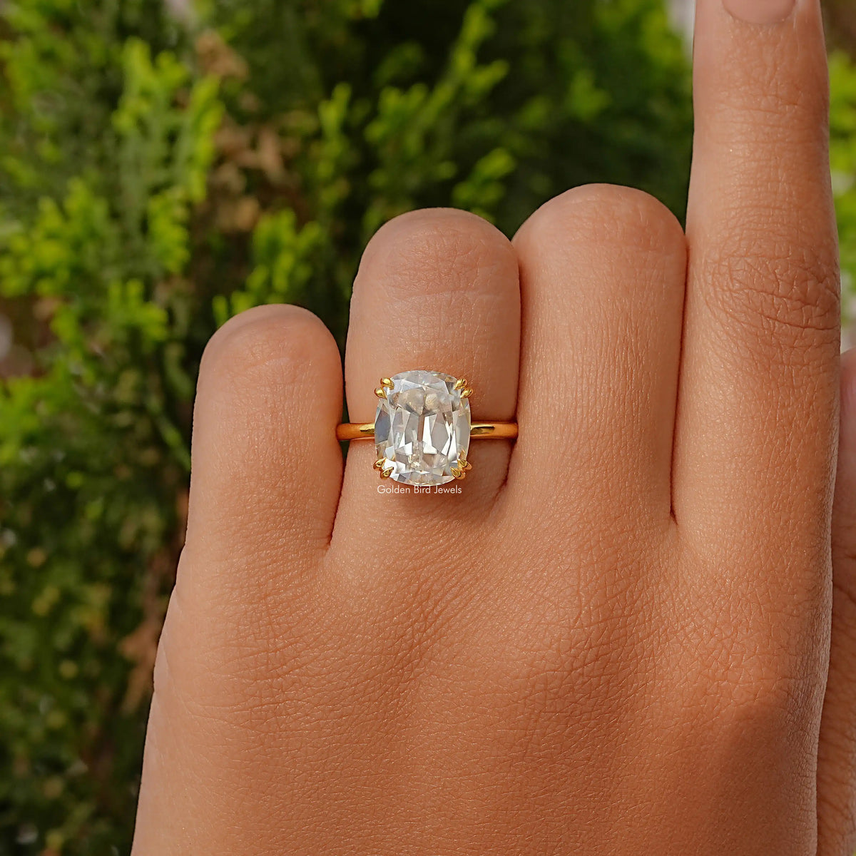 Gold-tone elongated cushion-cut solitaire moissanite ring with prong-set center stone