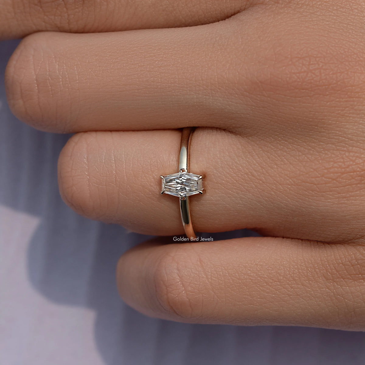Gold-tone solitaire ring with baguette-cut moissanite center stone, side view