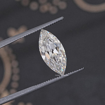 Loose marquise-cut moissanite gemstone, held in metal tweezers