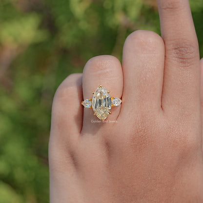 Three-stone pear and round moissanite ring with gold-tone prong setting