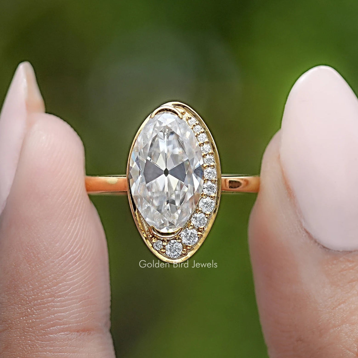 Oval moissanite engagement ring with gold band and diamond-like halo settings