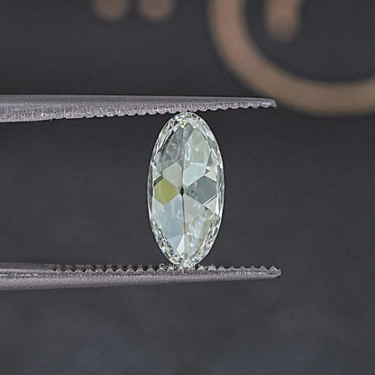 Close-up oval lab-grown diamond held between metal rails