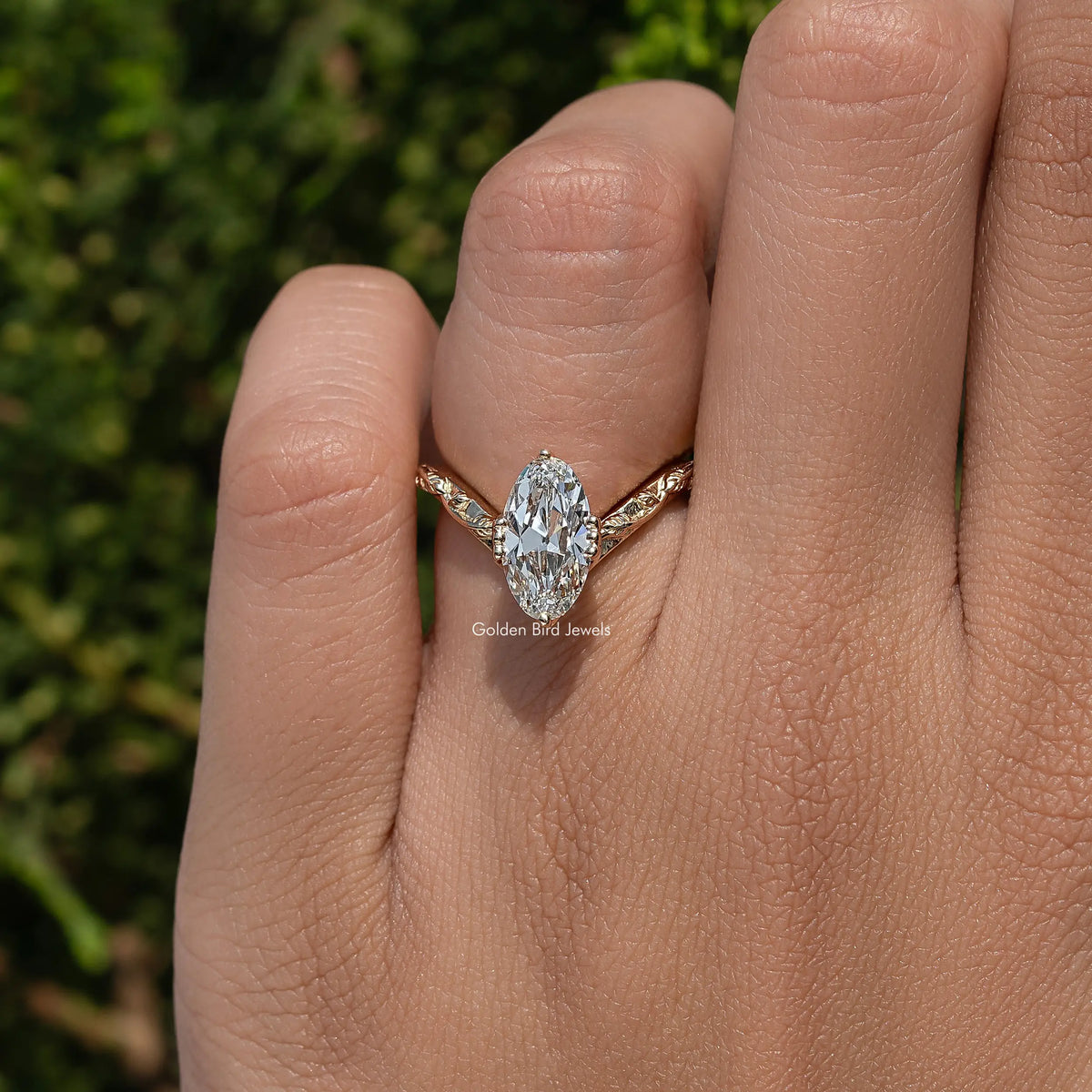 Curved diamond ring with large center stone and gold-tone setting on hand