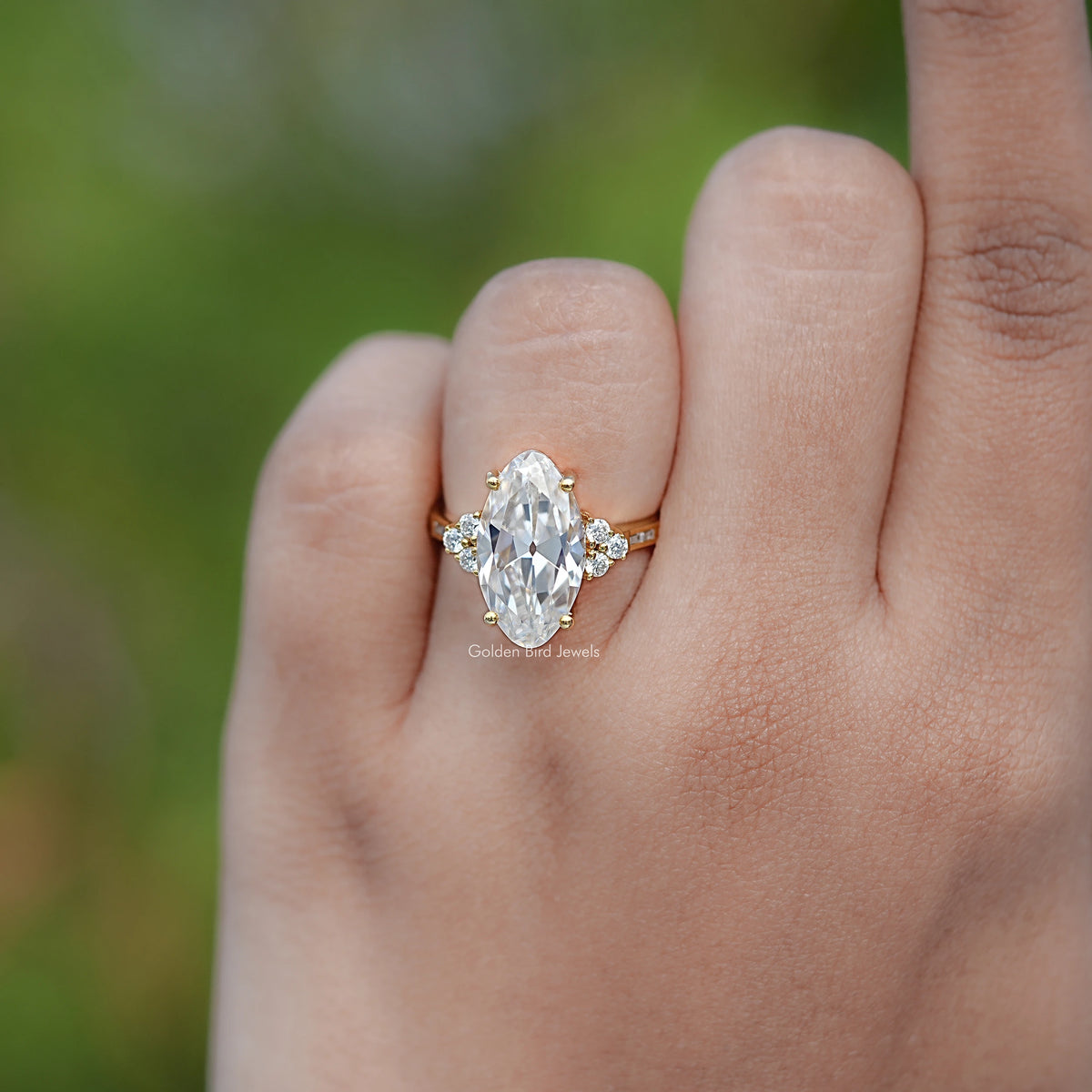 Gold-tone oval moissanite ring with small round side stones, prong set