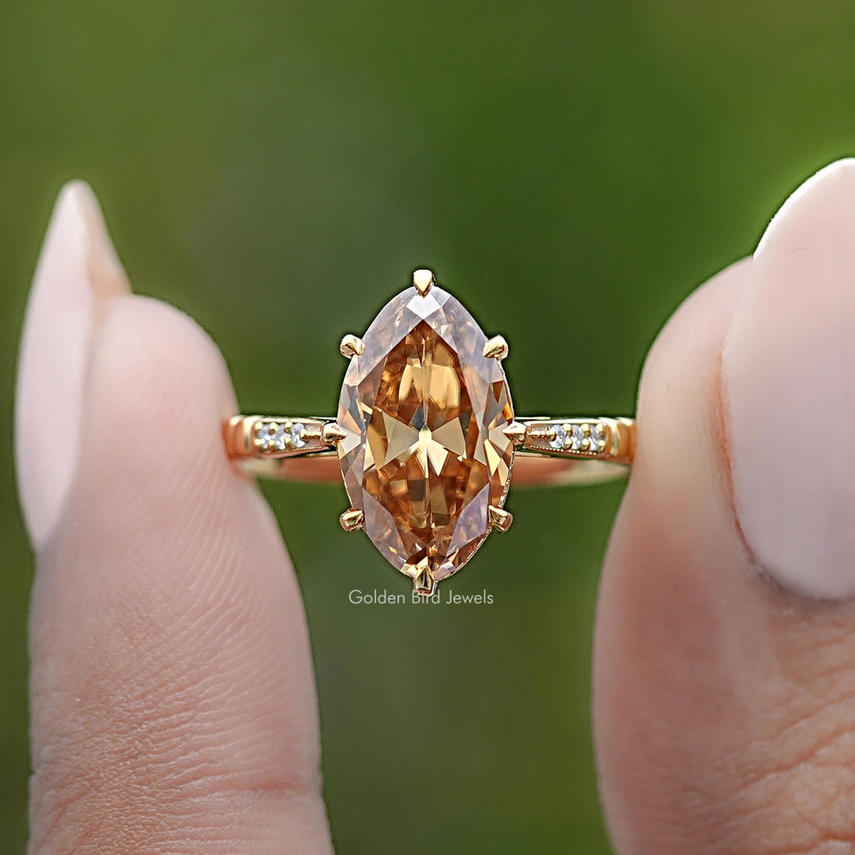 Gold-tone ring with oval amber center stone and small baguette side stones, close-up