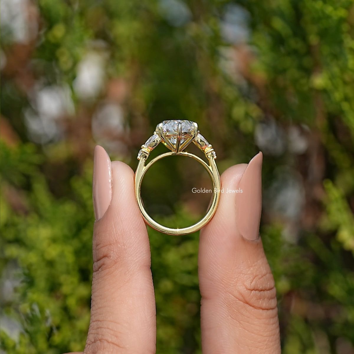 Engagement ring from side view with oval moissanite and yellow gold-tone halo details