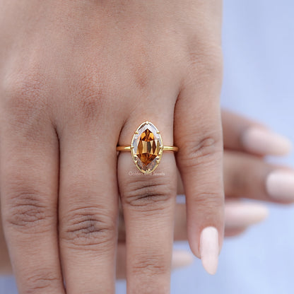 Gold-tone oval champagne solitaire ring on hand, side profile view