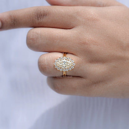 Gold-tone oval moissanite halo engagement ring on open palm, close