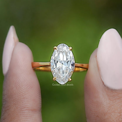 Gold oval moissanite ring with hidden halo, centered front view