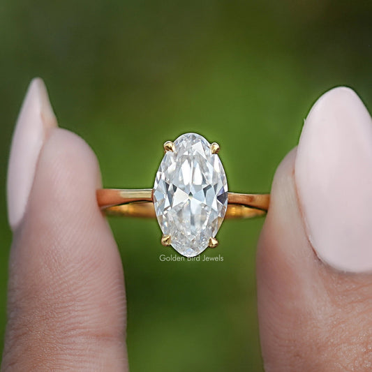 Gold oval moissanite ring with hidden halo, centered front view