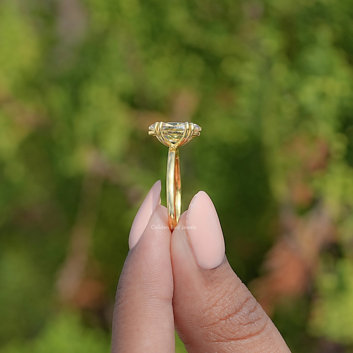 Gold solitaire ring top view showing oval center stone set with prongs