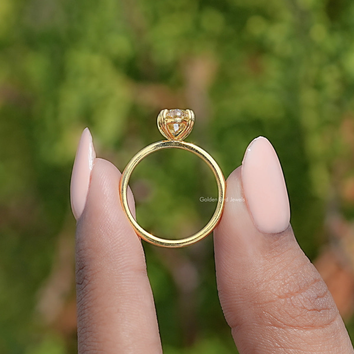 Gold solitaire ring underside view with oval center stone and prong setting