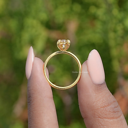 Gold solitaire ring underside view with oval center stone and prong setting