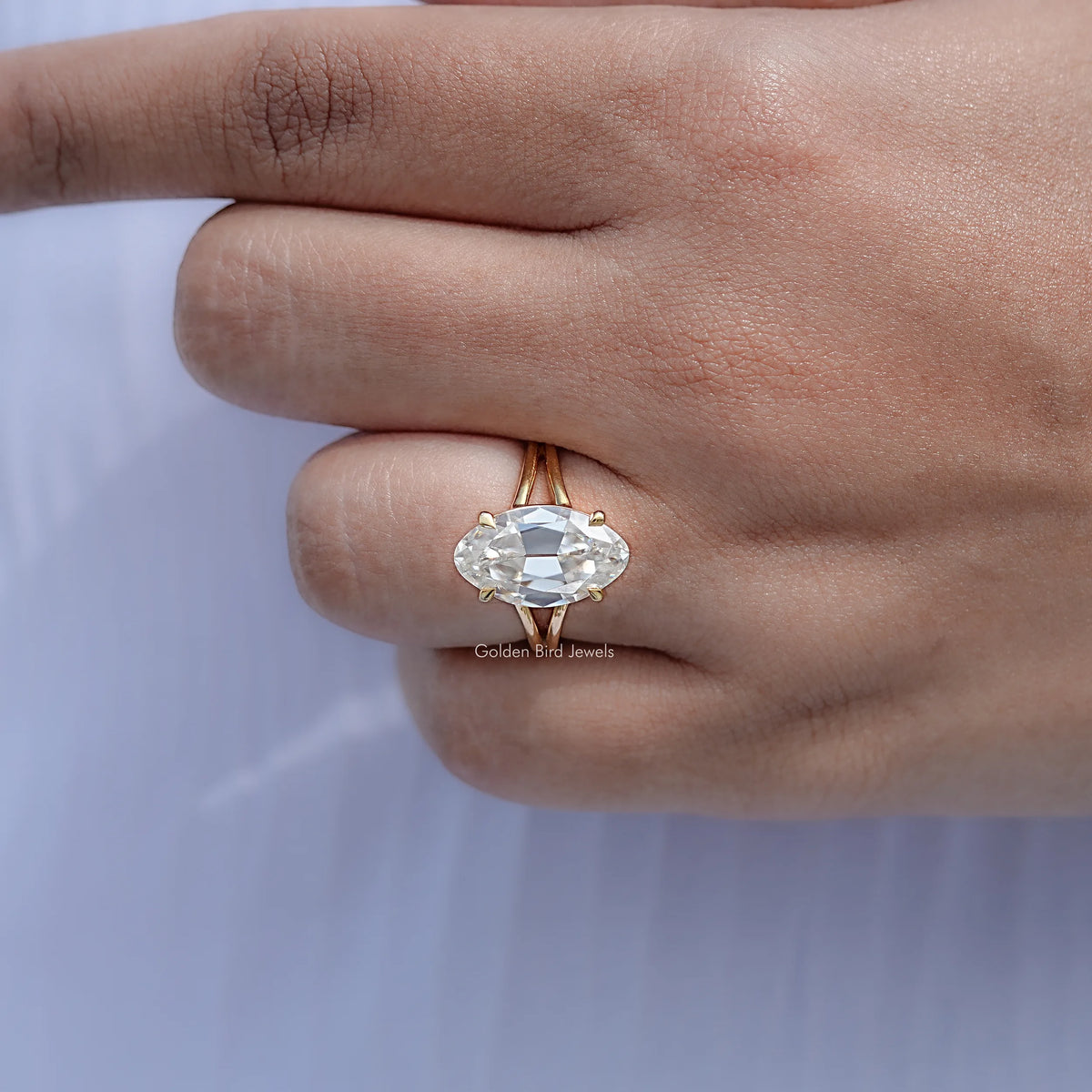 Gold moissanite solitaire ring with oval center stone and split shank, side view