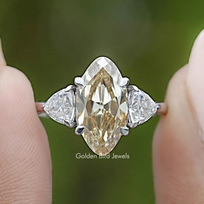 Prong-set three-stone ring close-up, center marquise stone with two side stones