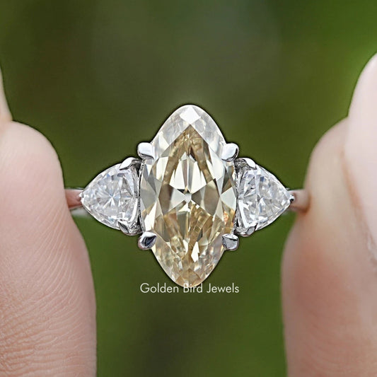 Prong-set three-stone ring close-up, center marquise stone with two side stones