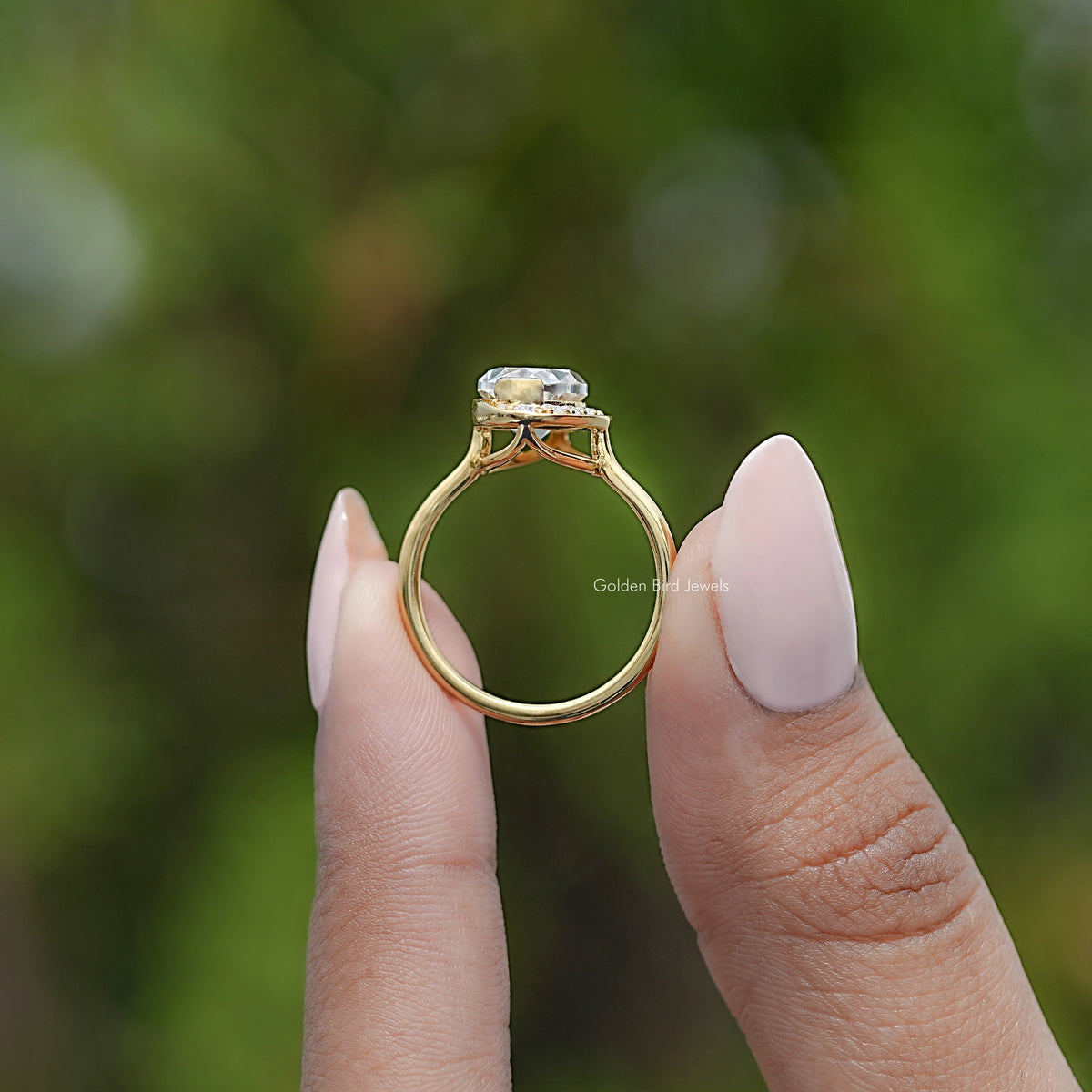 Back view of gold ring with oval moissanite and prong-set halo top